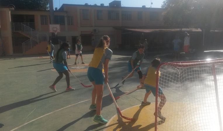 Students playing floor hockey