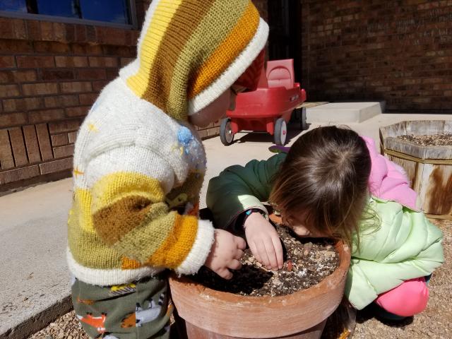 Photo of small children with potted tulips