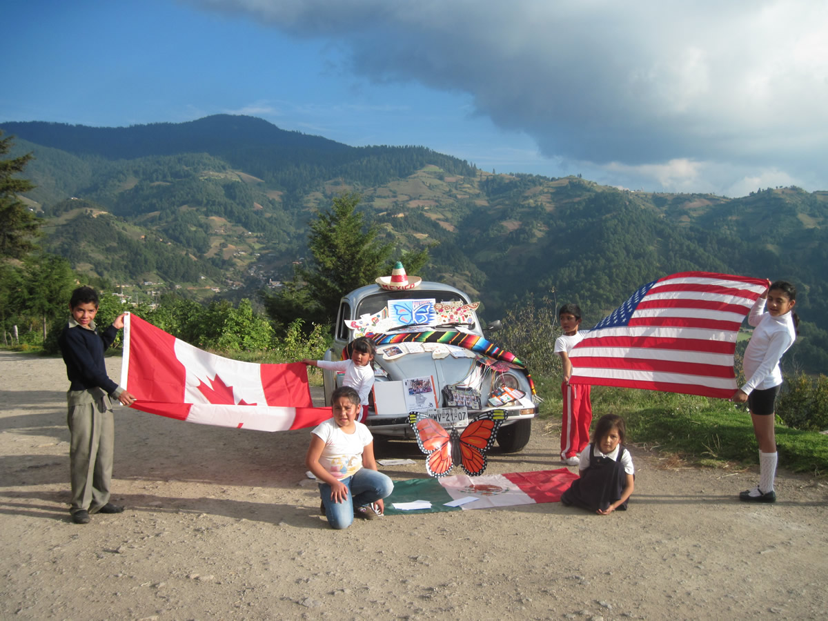 Photo of three flags and kids in Mexico