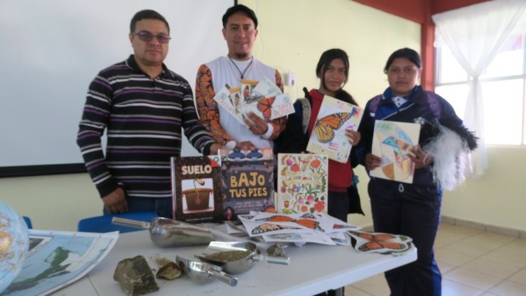 Four teachers hold donated books at Miguel Hidalgo Middle School in Mexico