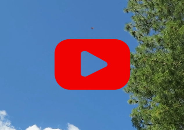 A blue sky with a red play button