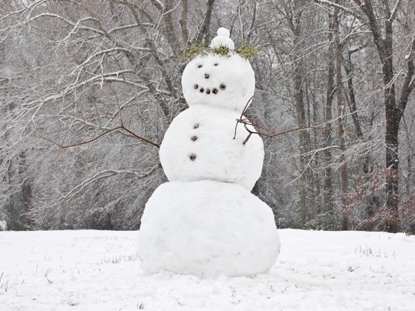 Photo  of snowman in spring snowfall. 