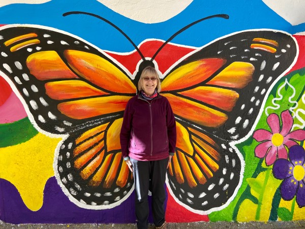 Susan Meyers in front of monarch mural