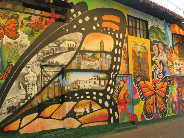 a monarch inspired mural painted along a wall in ANgangueo, Michoacan, Mexico. 