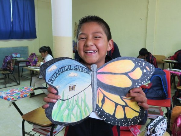 a student in Mexico holding an ambassador butterfly