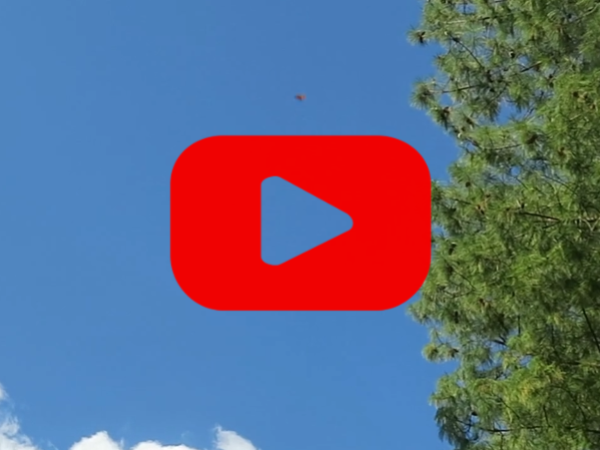 A blue sky with a red play button