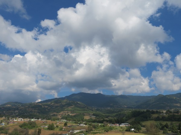 Blue skies with fluffy white clouds over a landscape